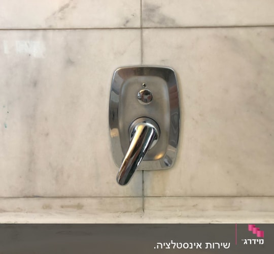 ידית ברז כרום על קיר שיש